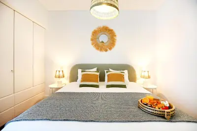 a bedroom with a bed with a bowl of fruit on it at Coast Guard Apartment in Faro
