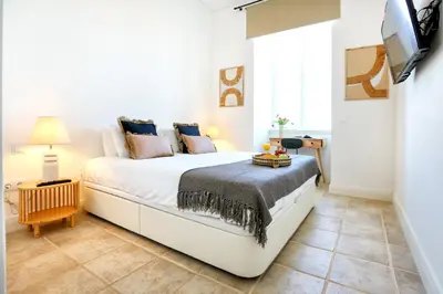 a small room with a bed and a table at Hot Breeze Apartment in Faro