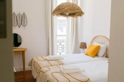 a bedroom with a bed and a window at President Pais Apartment in Faro