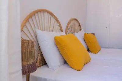 a bed with two chairs with pillows on it at President Pais Apartment in Faro
