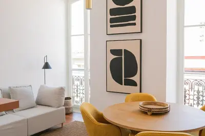 a living room with a table and yellow chairs at President Pais Apartment in Faro