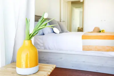 a yellow vase sitting on a table in a bedroom at Salty Spot Apartment in Faro