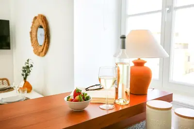 a table with a glass of wine and a bowl of fruit at Salty Spot Apartment in Faro