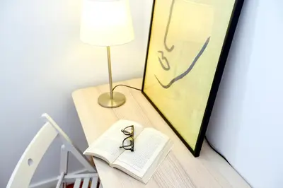 a table with a book and a pair of scissors on it at Xtraordinary Moments Apartment in Faro