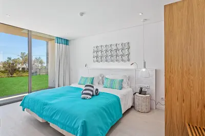 a bedroom with a large bed and a large window at Balaia Senses in Albufeira