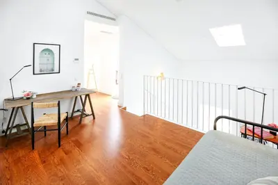 a living room with a table and a bed at Young Spirit Apartment in Faro