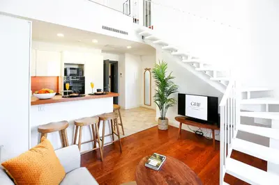 a living room with a staircase and a kitchen at Young Spirit Apartment in Faro