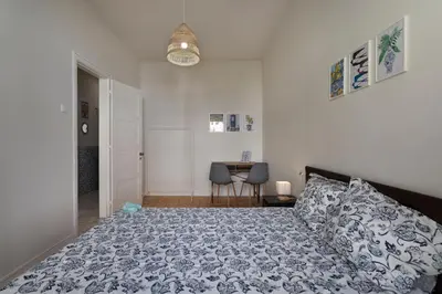 a bedroom with a bed and a table with chairs at Lemon Hostel Faro in Faro