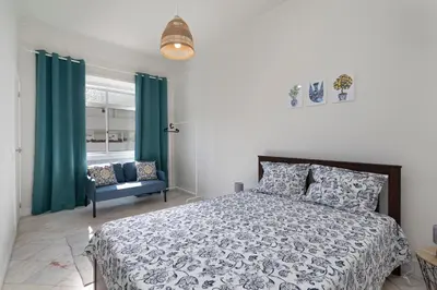 a bedroom with a bed and green curtains and a chair at Lemon Hostel Faro in Faro