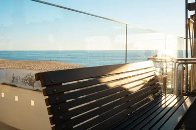 a bench on a balcony with a view of the ocean at Wax Suite By the sea in Faro