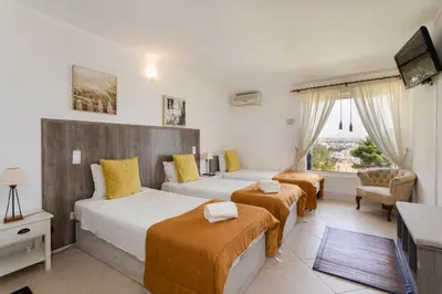 a hotel room with two beds and a television at The Albufeira Concierge - Moinho Sea Views & Pool in Albufeira