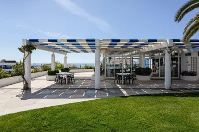 a pergola with tables and chairs on a patio at The Albufeira Concierge - Moinho Sea Views & Pool in Albufeira