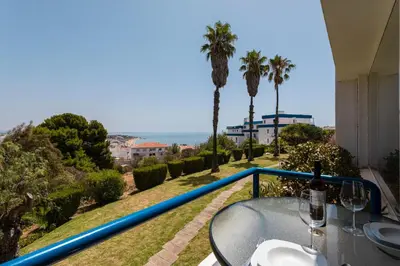 a table with wine glasses on a balcony with the ocean at The Albufeira Concierge - Moinho Sea Views & Pool in Albufeira