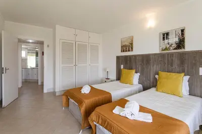 a bedroom with two beds with yellow and white sheets at The Albufeira Concierge - Moinho Sea Views & Pool in Albufeira