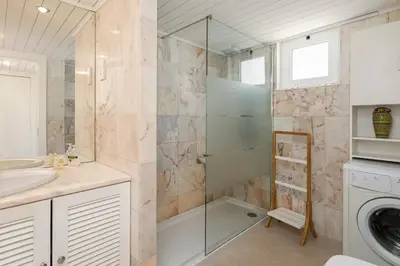 a bathroom with a sink and a washing machine at The Albufeira Concierge - Moinho Sea Views & Pool in Albufeira