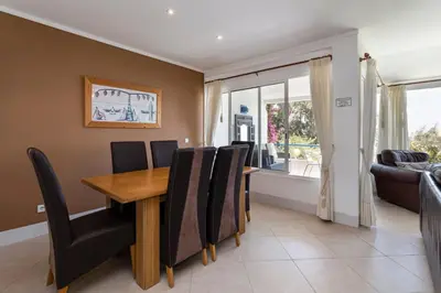 a dining room with a wooden table and black chairs at The Albufeira Concierge - Moinho Sea Views & Pool in Albufeira