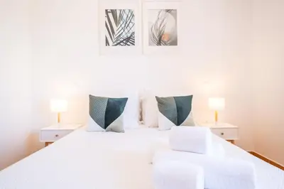 a bedroom with a white bed with two lamps at Villa Jasmin - Galé Bay in Albufeira