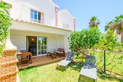 a backyard with two chairs and a table at Villa Jasmin - Galé Bay in Albufeira