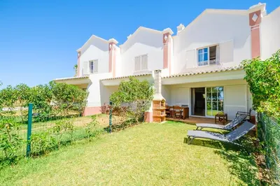 a white house with a fence and a yard at Villa Jasmin - Galé Bay in Albufeira