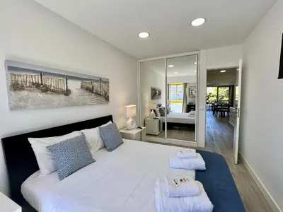 a bedroom with a large white bed with blue pillows at Quarteira Stylish 1 by Homing in Quarteira