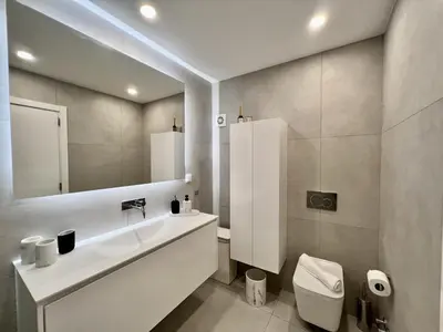 a bathroom with a sink and a toilet and a mirror at Quarteira Stylish 1 by Homing in Quarteira