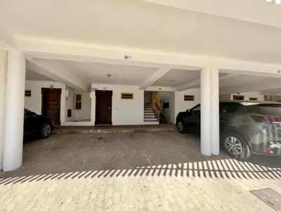 two cars parked in a garage with columns at Quarteira Stylish 1 by Homing in Quarteira