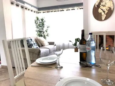 a dining room table with wine glasses and a couch at The Albufeira Concierge - Moinho Pool & Gardens in Albufeira
