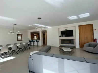 a living room with a couch and a dining room at Light House Luxury Villa in Albufeira