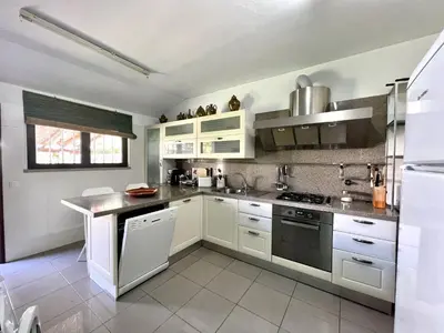 a kitchen with white cabinets and a stove top oven at Vilamoura Traditional Villa with Pool by Homing in Vilamoura