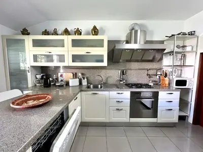 a kitchen with white cabinets and a counter top at Vilamoura Traditional Villa with Pool by Homing in Vilamoura