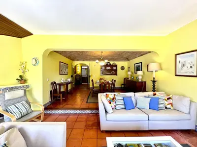 a living room with a couch and a dining room at Vilamoura Traditional Villa with Pool by Homing in Vilamoura