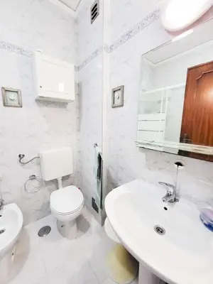 a white bathroom with a toilet and a sink at T2-MAMAMIA II Frente Mar in Quarteira