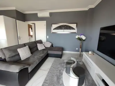 a living room with a couch and a flat screen tv at Casa das Oliveiras o seu refugio no Algarve in Quarteira