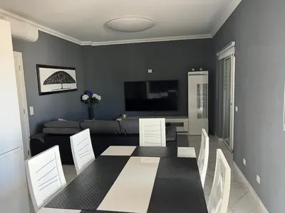 a living room with a table and a couch at Casa das Oliveiras o seu refugio no Algarve in Quarteira