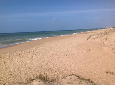a sandy beach with the ocean in the background at Apartamentos Barracuda in Faro