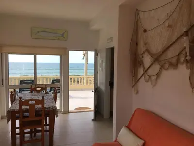 a living room with a table and a view of the ocean at Apartamentos Barracuda in Faro