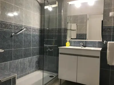 a bathroom with a shower and a sink and a tub at Apartamentos Barracuda in Faro