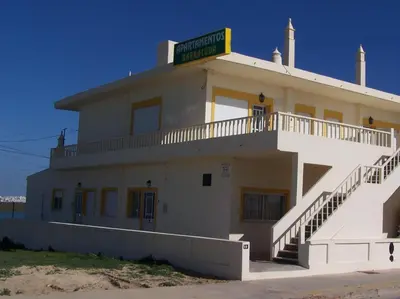 a white building with a sign on top of it at Apartamentos Barracuda in Faro
