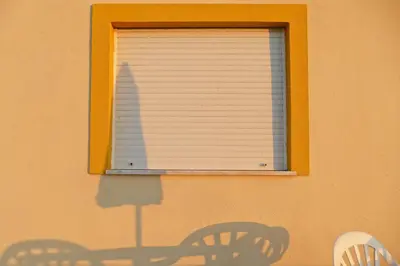 a shadow of a window with a window blind at Apartamentos Barracuda in Faro