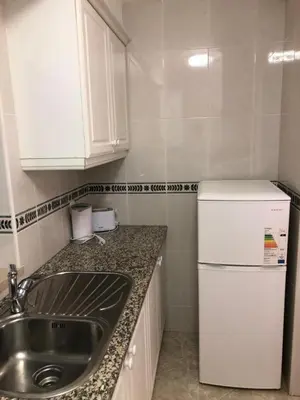 a kitchen with a sink and a refrigerator at Torre da Aldeia by Umbral in Albufeira