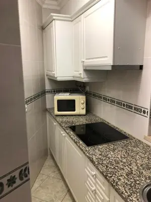 a kitchen with white cabinets and a microwave at Torre da Aldeia by Umbral in Albufeira