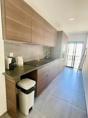 a kitchen with wooden cabinets and a trash can at Pontinha Exclusive House in Faro