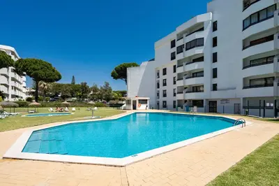 a swimming pool in front of a building at TENNIS GOLF MAR - Apartamento renovado para 4 com AC e piscina in Vilamoura