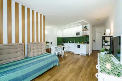 a living room with a bed and a kitchen at TENNIS GOLF MAR - Apartamento renovado para 4 com AC e piscina in Vilamoura
