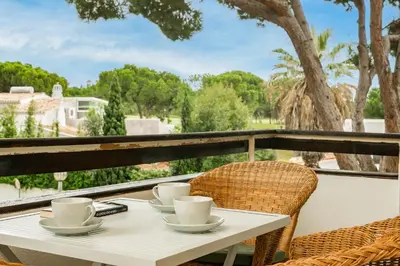 a table with cups and saucers on a balcony at TENNIS GOLF MAR - Apartamento renovado para 4 com AC e piscina in Vilamoura