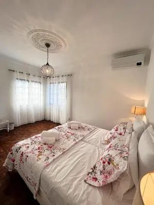 a bedroom with a large bed with two chairs on it at Sunshine Villa with Heated Pool in Faro