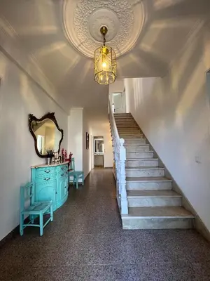 a hallway with stairs and a blue cabinet and a mirror at Sunshine Villa with Heated Pool in Faro