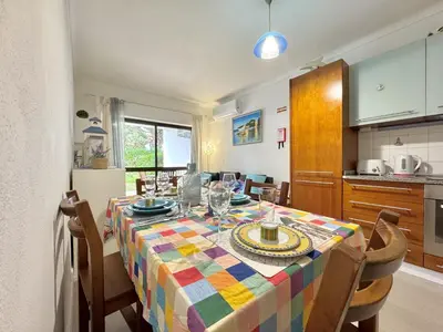 a kitchen and dining room with a table and chairs at Albufeira Cosy by Homing in Albufeira