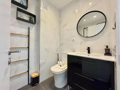 a bathroom with a toilet and a mirror at Albufeira Cosy by Homing in Albufeira
