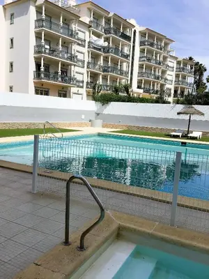 a swimming pool in front of a large building at 1 Bedroom Apartment Chaves, Praceta Vitorino Nemesio, Albufeira in Albufeira